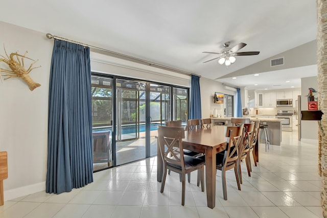 dining space featuring ceiling fan, lofted ceiling, and light tile patterned floors