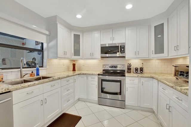 kitchen with sink, white cabinetry, stainless steel appliances, and tasteful backsplash