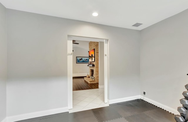 spare room featuring a fireplace and light tile patterned floors