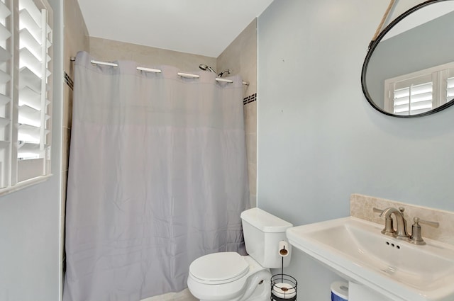 bathroom featuring toilet, sink, and walk in shower