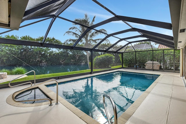 view of swimming pool featuring glass enclosure, a patio area, and a water view