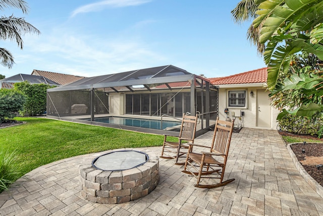 view of patio featuring glass enclosure and an outdoor fire pit