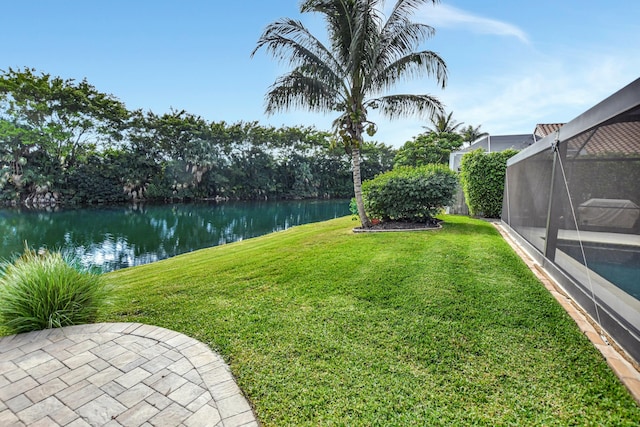 view of yard with a water view and glass enclosure