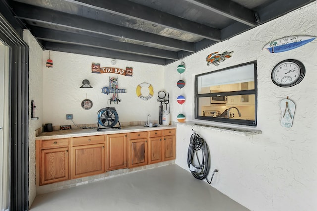 bar featuring beam ceiling and sink