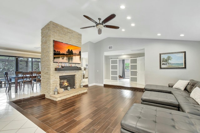 living room featuring a fireplace, hardwood / wood-style flooring, ceiling fan, and lofted ceiling