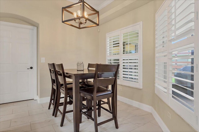 dining space featuring crown molding and a chandelier