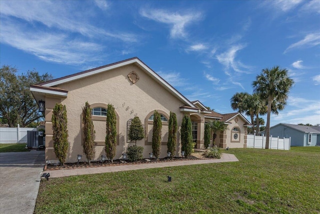 exterior space with central AC unit and a front yard