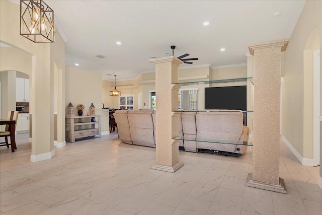 living room featuring ornate columns, ornamental molding, and ceiling fan with notable chandelier