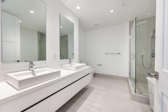 bathroom featuring tile patterned floors, vanity, toilet, and a shower with shower door