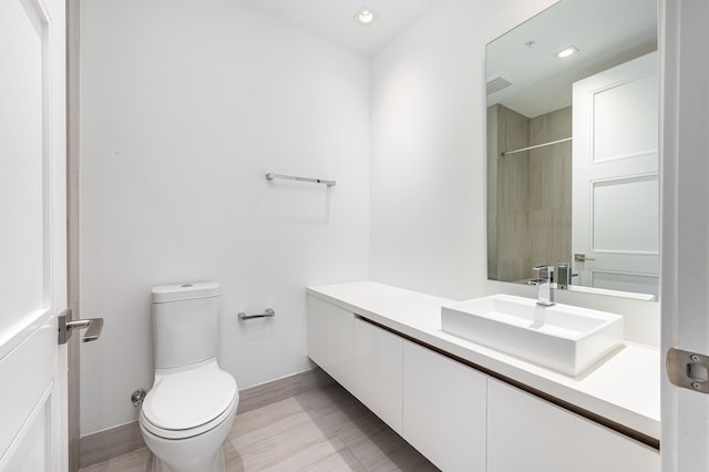 bathroom featuring vanity, toilet, and walk in shower