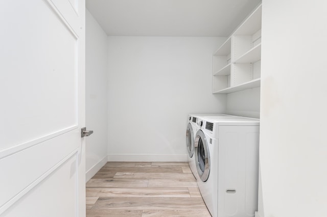 clothes washing area featuring washer and dryer and light hardwood / wood-style floors