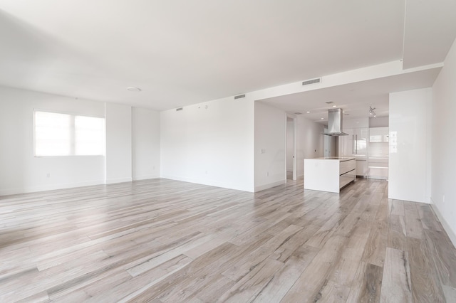 unfurnished living room with light hardwood / wood-style floors and plenty of natural light