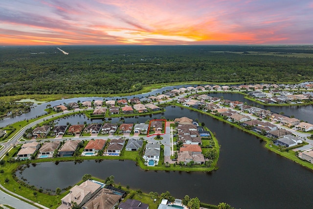 aerial view at dusk featuring a water view