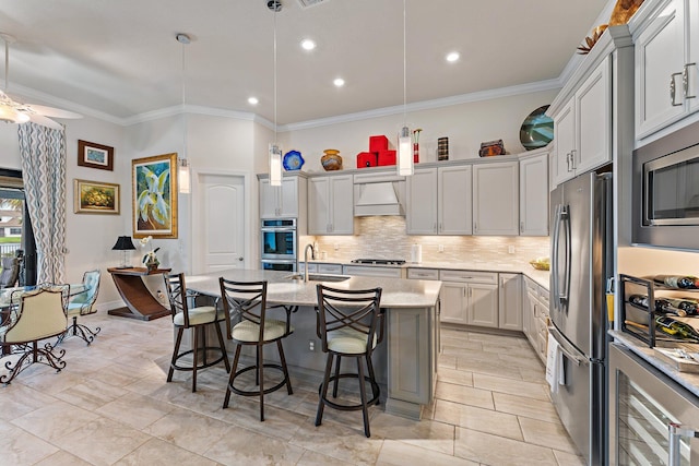 kitchen featuring pendant lighting, sink, an island with sink, appliances with stainless steel finishes, and a breakfast bar area