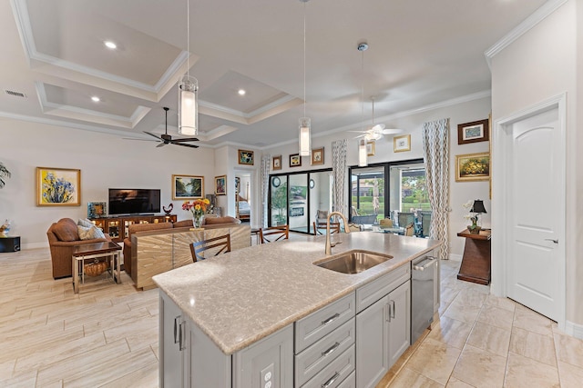 kitchen with light stone countertops, a kitchen island with sink, sink, decorative light fixtures, and dishwasher