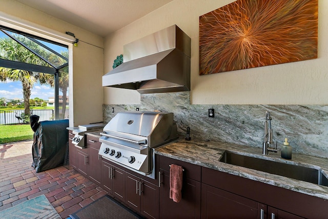 view of patio / terrace featuring sink, glass enclosure, grilling area, and exterior kitchen