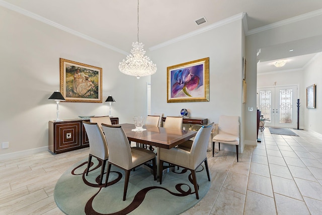 dining area with an inviting chandelier, ornamental molding, and french doors