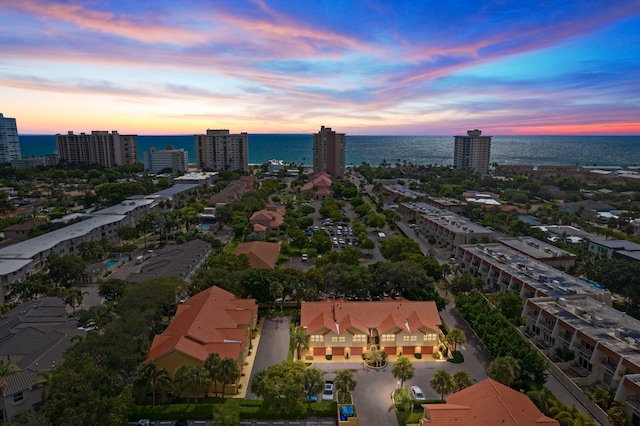 aerial view at dusk featuring a water view