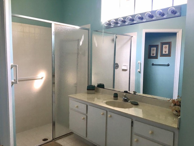 bathroom featuring tile patterned flooring, vanity, and walk in shower