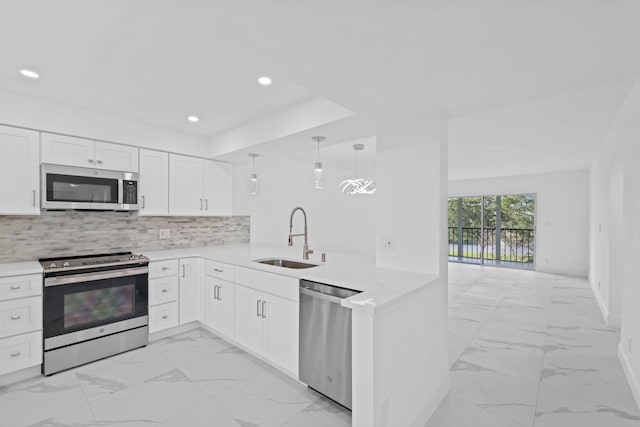 kitchen featuring kitchen peninsula, sink, white cabinets, and appliances with stainless steel finishes