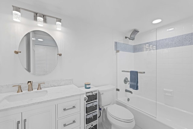 full bathroom featuring vanity, tiled shower / bath combo, and toilet