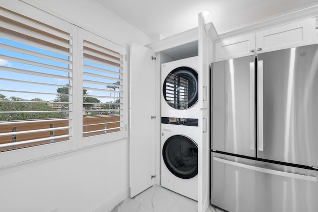 clothes washing area featuring stacked washer and clothes dryer