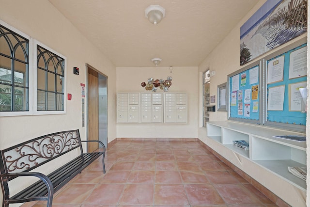 hall with built in shelves, tile patterned floors, and a mail area