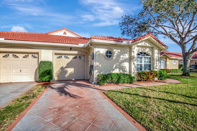 mediterranean / spanish home featuring a garage and a front lawn