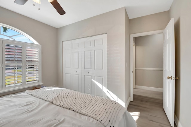 bedroom with ceiling fan, light wood-type flooring, and a closet