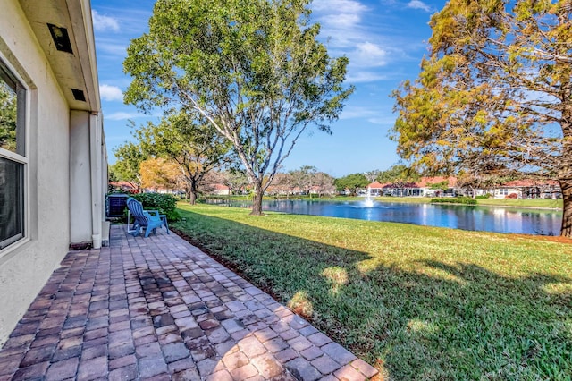 view of yard with a water view and a patio