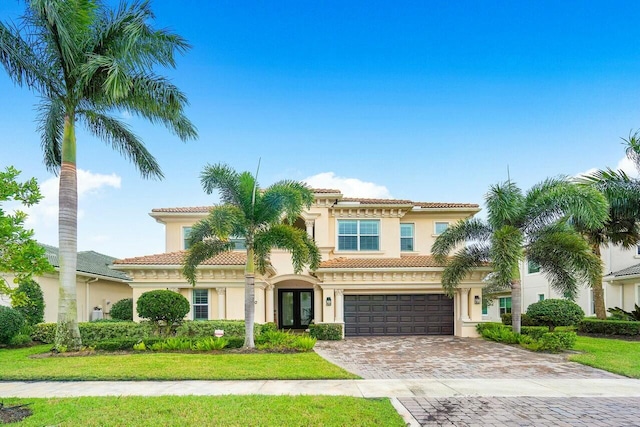 mediterranean / spanish-style house with a garage and french doors