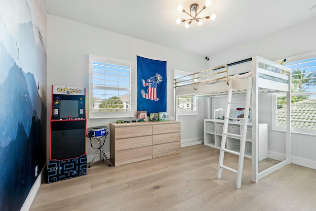 bedroom with light hardwood / wood-style floors and a chandelier