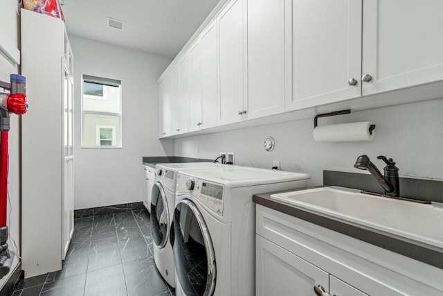 washroom featuring cabinets, sink, and washing machine and clothes dryer