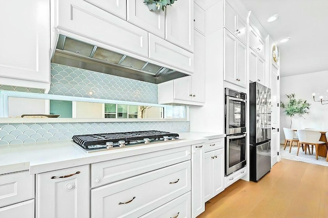 kitchen featuring white cabinets, light wood-type flooring, and stainless steel appliances