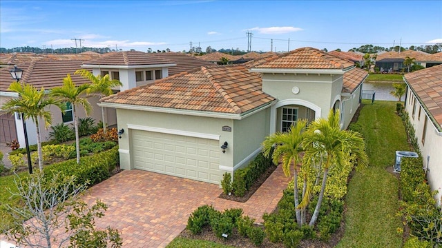 mediterranean / spanish house with a garage and central AC