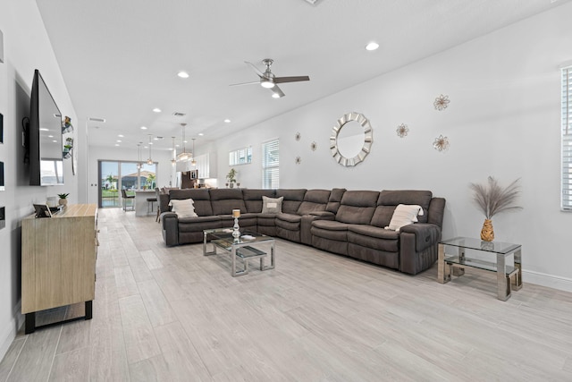 living room with ceiling fan and light hardwood / wood-style flooring