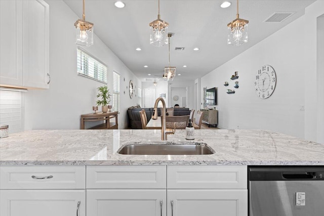 kitchen featuring decorative light fixtures, white cabinetry, stainless steel dishwasher, and sink