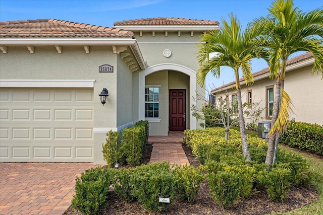 property entrance with central AC unit and a garage