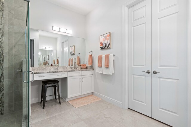 bathroom with tile patterned flooring, vanity, and walk in shower