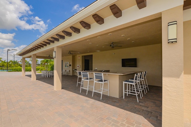 view of patio featuring ceiling fan and an outdoor bar