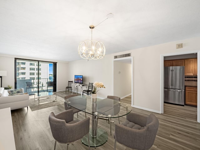 dining area with expansive windows, visible vents, baseboards, and wood finished floors