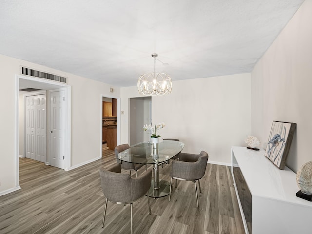 dining area with baseboards, visible vents, and wood finished floors