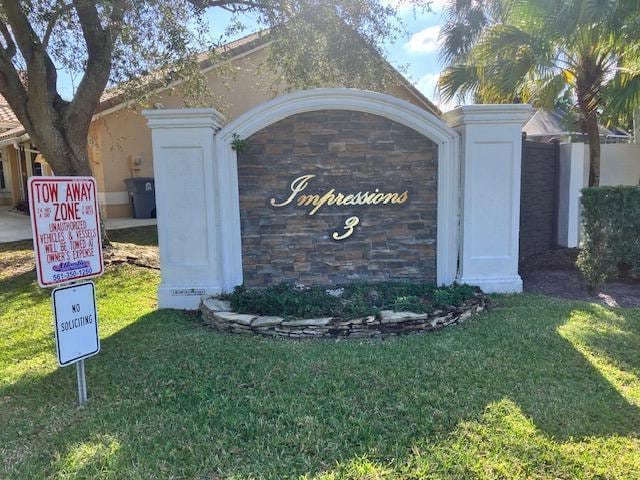 community / neighborhood sign with a lawn