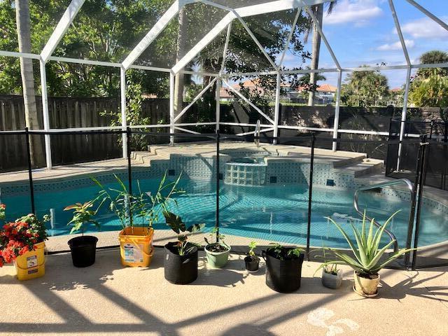 view of pool with glass enclosure and a patio area