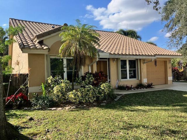 view of front of home featuring a garage and a front lawn