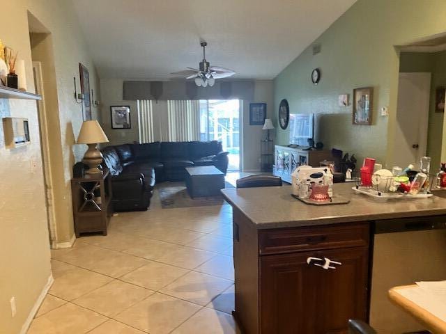 kitchen with dark brown cabinetry, ceiling fan, dishwasher, lofted ceiling, and light tile patterned flooring