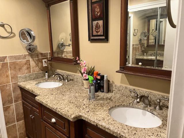 bathroom featuring vanity and tile walls