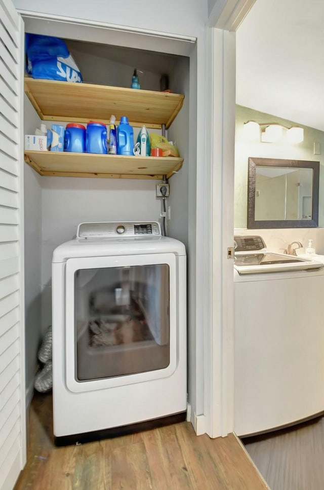 clothes washing area featuring hardwood / wood-style floors and washer / clothes dryer