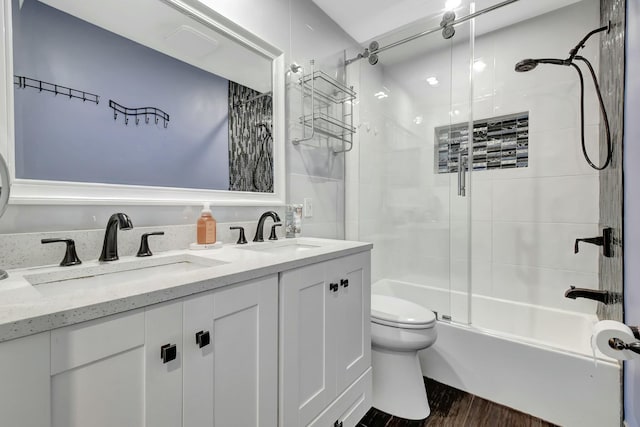 full bathroom with vanity, hardwood / wood-style flooring, toilet, and enclosed tub / shower combo