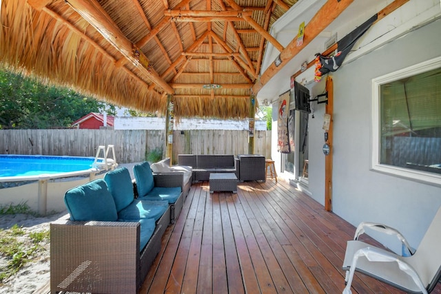 wooden deck featuring an outdoor living space and a fenced in pool